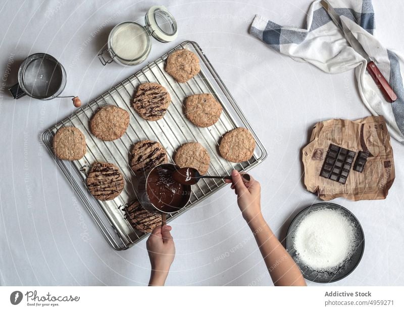 Anonyme Frau überzieht Kekse mit Schokolade Hand lecker Beteiligung Zucker köstlich Partyessen Schalen & Schüsseln Rezept hausgemachte Speisen Keksstapel