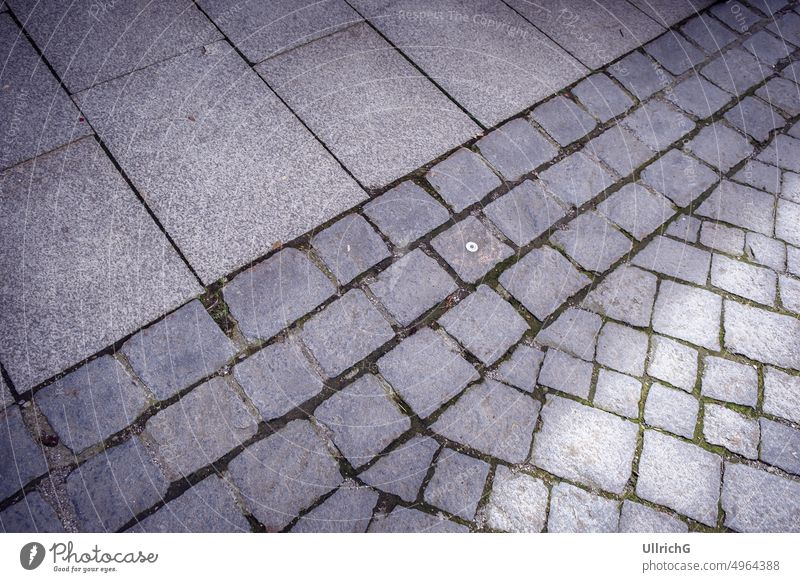 Städtischer Bildhintergrund aus Bürgersteig und Kopfsteinpflaster einer Straße. Stein Straßenbelag Gasse Fahrspur urban Hintergrund Struktur Muster Textur