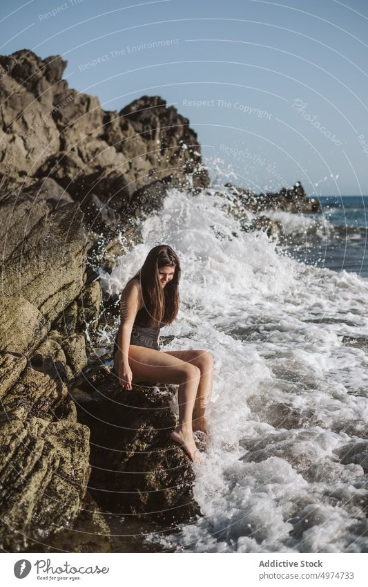 Frau rastend am felsigen Strand Klippe Schönheit Stil Natur Kokette MEER Meer hübsch brünett lange Haare Stehen romantisch trendy verführerisch Sommer Urlaub