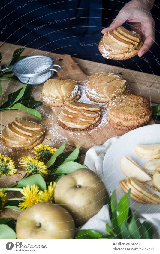 Kropfträger nimmt Törtchen vom Tisch Person Apfel Dessert Küche heimwärts Lebensmittel frisch lecker Mahlzeit geschmackvoll Keks Sieb Biskuit Feinschmecker