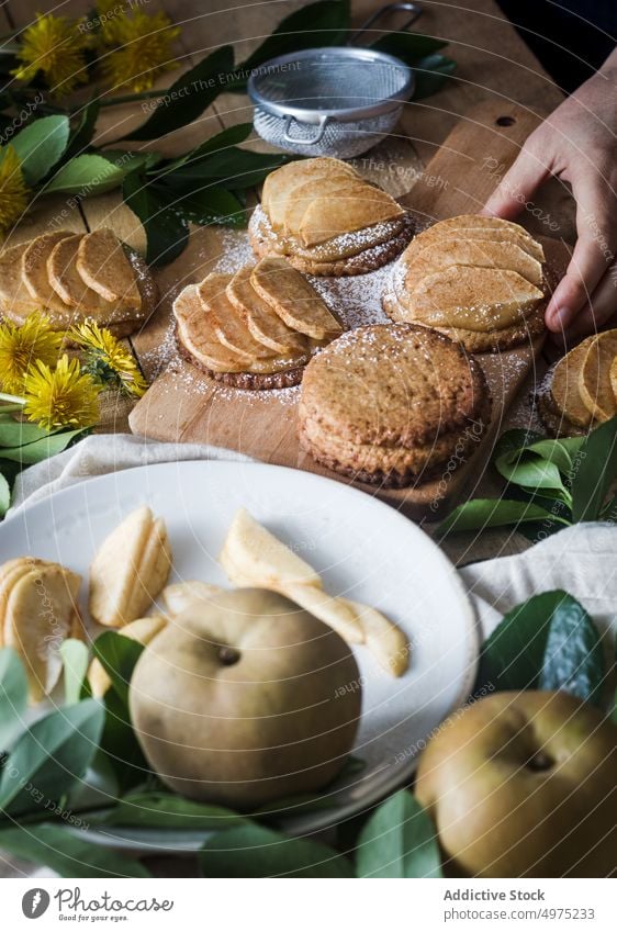 Kropfträger nimmt Törtchen vom Tisch Person Apfel Dessert Küche heimwärts Lebensmittel frisch lecker Mahlzeit geschmackvoll Keks Sieb Biskuit Feinschmecker