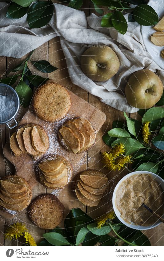 Kekse mit Äpfeln auf dem Tisch Apfel Törtchen Dessert Küche heimwärts Lebensmittel Schneidebrett Löwenzahn lecker Scheibe Mahlzeit geschmackvoll frisch Sieb