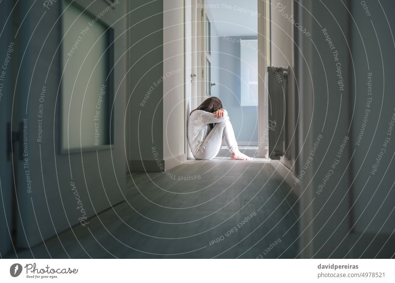 Frau im Schlafanzug sitzt auf dem Boden eines psychiatrischen Zentrums unkenntlich Pyjama mental Erkrankung Zentrum für psychische Gesundheit Probleme Sitzen