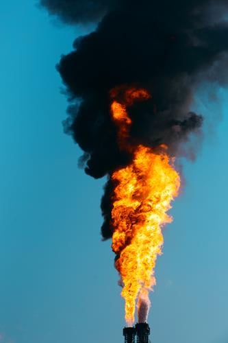 Gasfackel in der Industrie. Stichflamme mit dunklem Rauch beim abfackeln von Gasen Fackel Flamme Gasflamme Petrochemie Chemie Feuer Qualm Industrieanlage