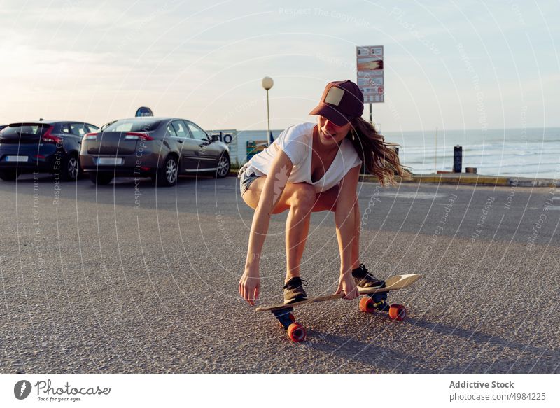 Schöne Skaterin übt Reiten Skateboard auf der Straße Frau Spaß urban schön jung Holzplatte trendy stylisch Jugend Skateboarderin Lifestyle Mädchen Sommer