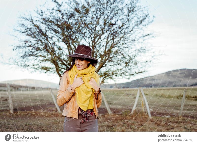 Stilvolle Frau mit Schal und Cowboyhut schön Ranch Natur Stehen Hut Cowgirl trendy nachdenklich träumend brünett Harmonie Zaun jung Landschaft Holz Lehnen