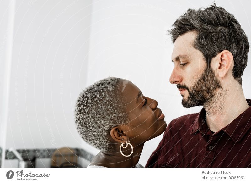 Zärtliches multiethnisches Paar zu Hause Liebe Umarmen heimwärts kuscheln Partnerschaft lässig Lächeln Zusammensein romantisch Zuneigung Afroamerikaner