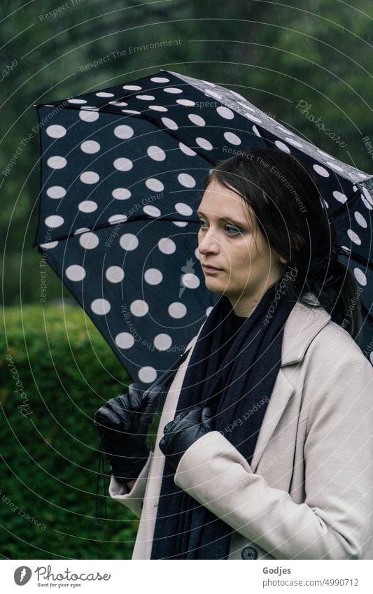 [HH Unnamed Road Tour] trauernde Frau mit Regenschirm auf dem Friedhof Trauer Traurigkeit Tod Grabstein Außenaufnahme Punkte Vergänglichkeit Religion & Glaube