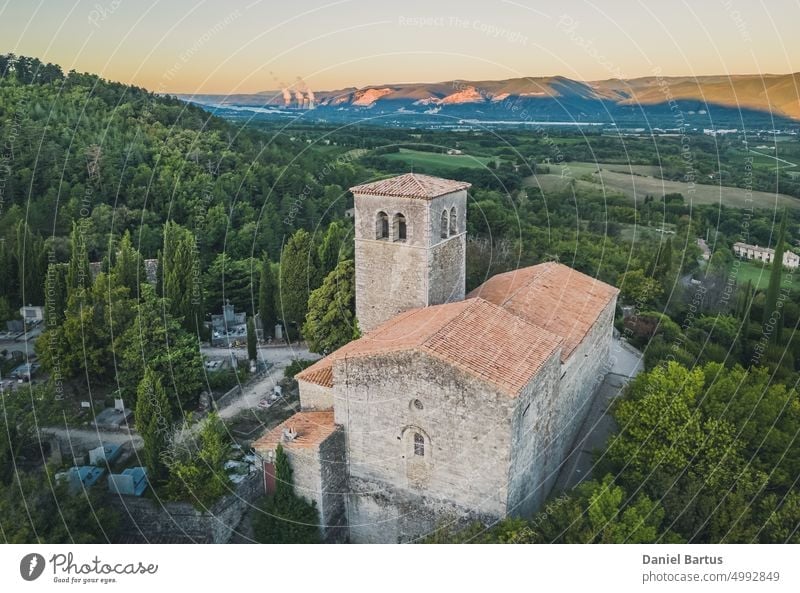Blick aus der Vogelperspektive auf die Kirche Sainte-Foy in einer der schönsten Städte Frankreichs - Mirmande. Im Hintergrund ein Blick auf das Kernkraftwerk Cruas