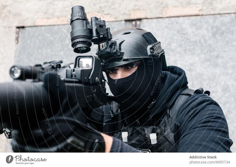 Anonyme Kämpfer mit Gewehren in der Nähe eines schäbigen Gebäudes Männer kämpfen Gefecht zwängen behüten Schlacht gewalttätig Gefahr attackieren zerquetschen