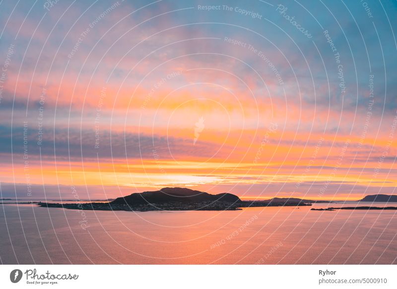 Alesund, Norwegen. Erstaunliche natürliche hellen dramatischen Himmel in warmen Farben über Alesund Valderoya und Inseln in Sonnenuntergang Zeit. Bunte Himmel Hintergrund. Schönheit in der norwegischen Natur