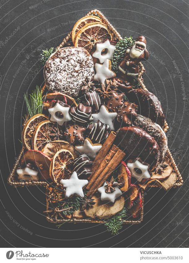 Weihnachtsbaum aus verschiedenen Backwaren, Keksen, Lebkuchen, Schokolade und Wintergewürzen. Ansicht von oben gemacht Gebäck Draufsicht rustikal braun Zimt