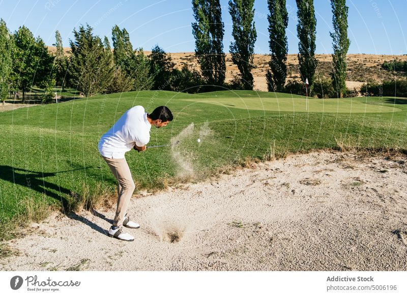 Profi-Sportler, der den Ball beim Golfspielen im Feld schlägt Golfer aufschlagen Gefahr Club professionell Mann Kurs Spiel schwierig Landschaft Gerät Reichtum