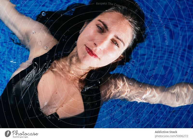 Junge Frau entspannt sich im Freibad im Sommer Pool Beckenrand sich[Akk] entspannen Schwimmer Kälte genießen sorgenfrei Wasser Sonnenbad Bikini Sonnenlicht