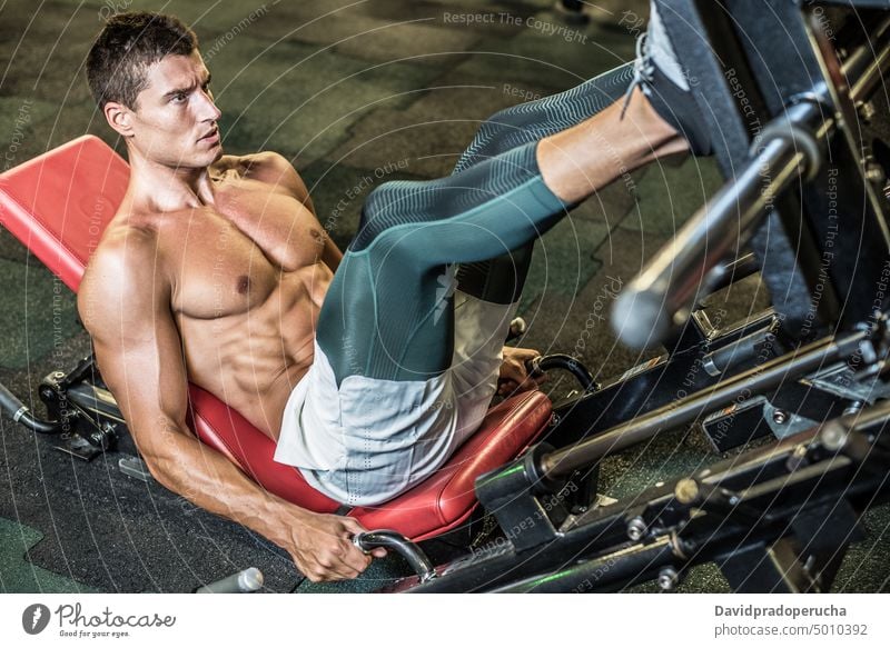 Mann macht Beintraining im Fitnessstudio Maschine Beine Gewichtheben muskulös passen Athlet Sport Übung Körper Training männlich Kraft Gesundheit Muskel stark