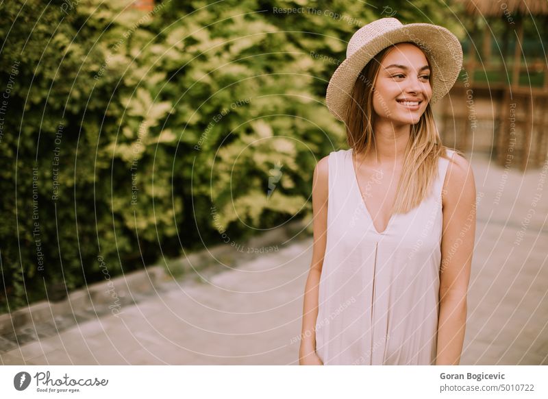 Junge Frau mit Hut geht im Garten des Resorts spazieren Urlaub Strand Reichtum Glück schön sonnig jung Tourismus Feiertag Sommer Natur sich[Akk] entspannen