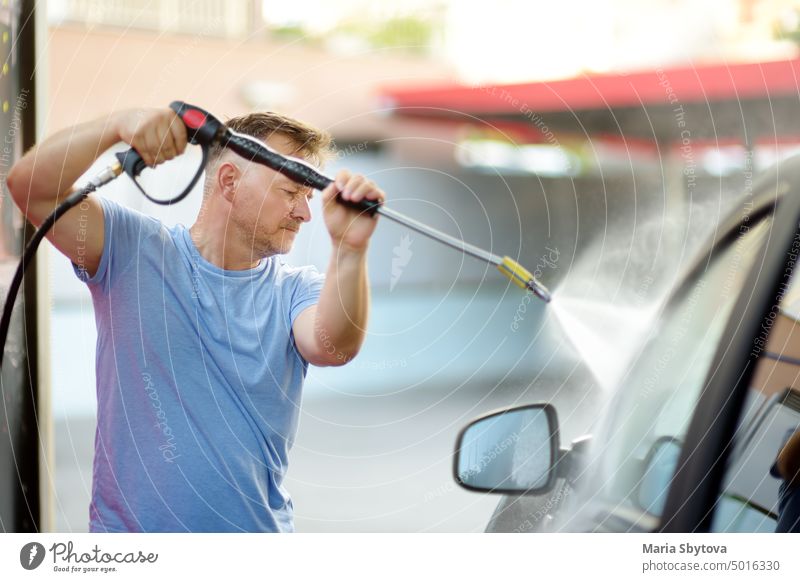 Autowäsche. Reifer Mann reinigt Auto mit Hochdruck-Wasserstrahl. Selbst PKW Waschen verwenden von selbst Person Wäsche waschen Sauberkeit Düsenflugzeug Spray