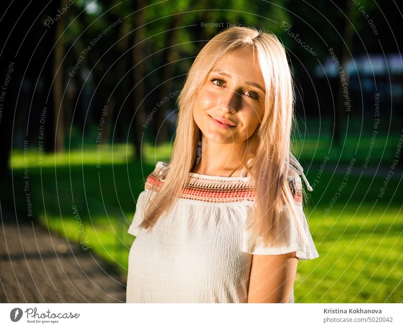 Schöne blonde Frau im weißen Kleid posiert auf grünem Hintergrund im Park im Sommer schön Schönheit Behaarung Lifestyle Porträt attraktiv niedlich Mode Glück