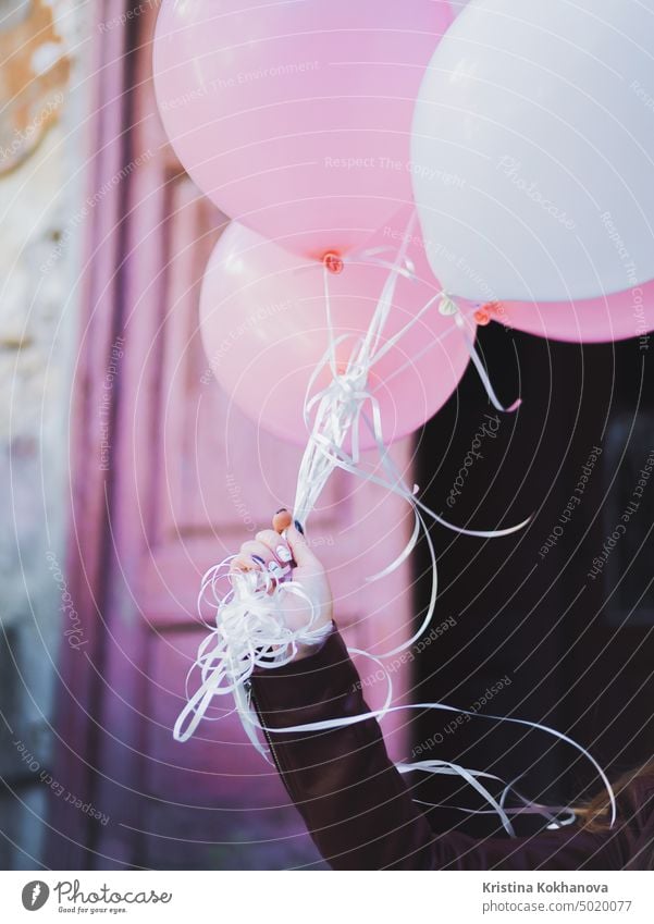 Hand mit bunten weißen und rosa Luftballons. Geburtstagskind, Urlaub feiern, Glückwünsche. Hintergrund Ballon schön Schönheit hell heiter farbenfroh niedlich