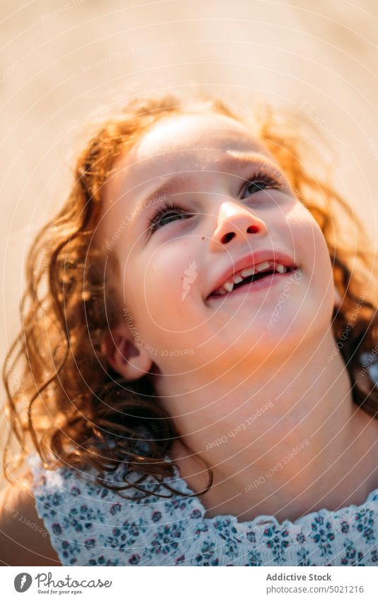 Aufgeregtes Mädchen schaut nach oben Kind heiter aufschauend Ingwer sonnig tagsüber wenig Lächeln aufgeregt Spaß Unschuld sorgenfrei rot krause Haare niedlich