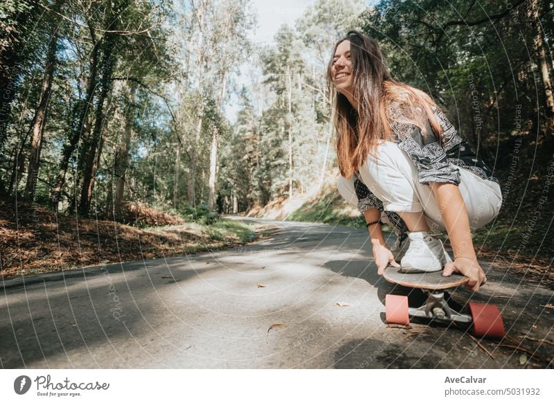 Sportliche Frau fährt auf dem Skateboard auf dem Waldweg. Longboarding, weiblich.Gen Z Sport Aktivität Bewegung Menschen Erwachsener Lifestyle Straße
