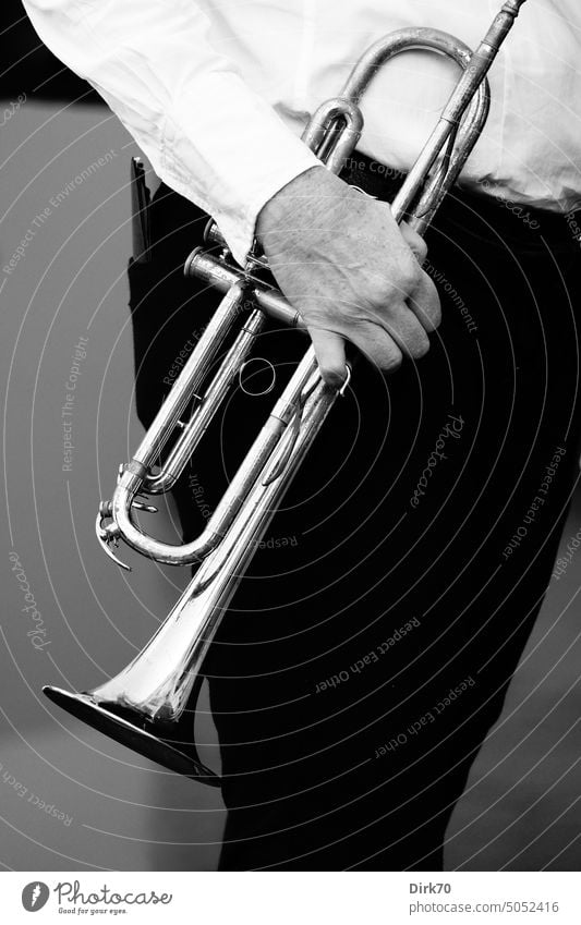Trompete, von einem Mann mit schwarzer Hose und weißem Hemd in der Hand gehalten Trompeter Blasmusik Blasinstrument Blasinstrumente Musik Musiker