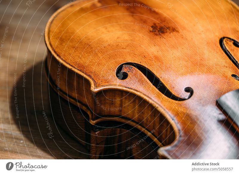 Handgefertigte Holzgeige auf der Werkbank Geige Werkstatt Instrument Handwerk Geigenbau Tisch Kunstgewerbler hölzern glänzend Herstellerin Inszenierung Basteln