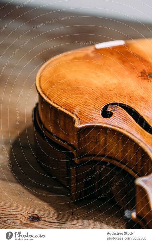 Handgefertigte Holzgeige auf der Werkbank Geige Werkstatt Instrument Handwerk Geigenbau Tisch Kunstgewerbler hölzern glänzend Herstellerin Inszenierung Basteln