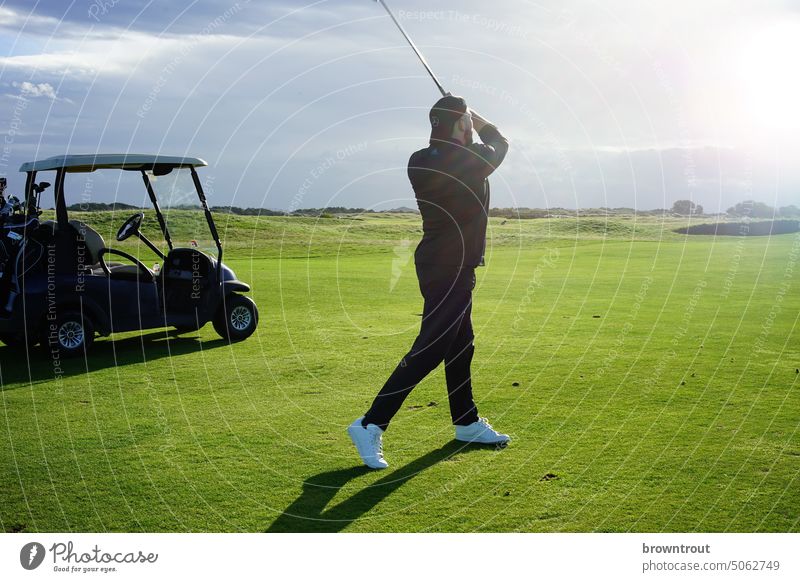 Golfspieler beim Schlag auf dem Fairway im Sonnenschein Golfer Golfplatz grün Sport Golfschläger Spielen Freizeit & Hobby Gras Außenaufnahme Rasen Abschlag