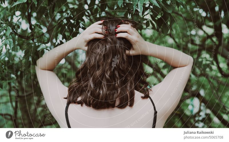 Frau mit braunen Locken im Wald Lifestyle stehen Natur jung Frühling Sommer Gelassenheit Naturverbundenheit Umweltschutz Leben ästhetisch Haare & Frisuren