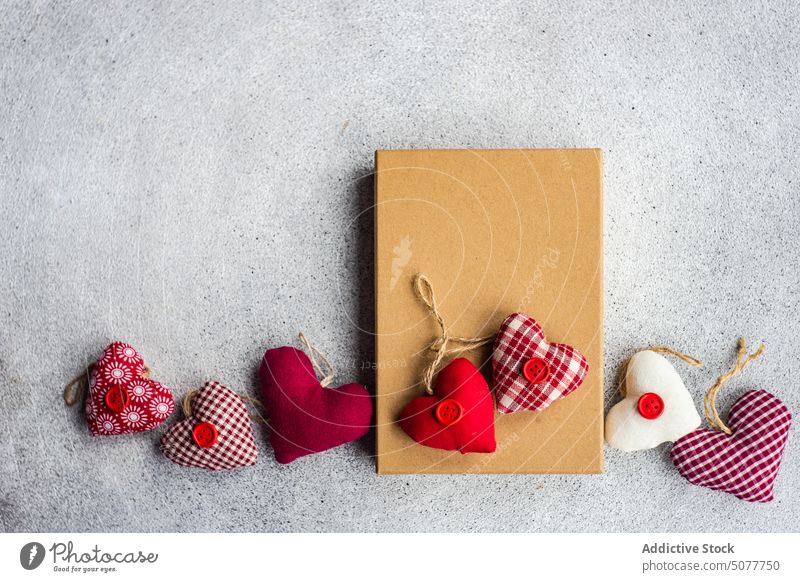 Rustikale Geschenkbox mit Textilherzen Valentinsgruß Tag Hintergrund Kasten Postkarte konkreter Hintergrund Engagement Gefühl festlich von Herz herzförmig