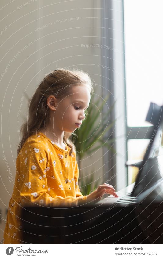 Kleines blondes Mädchen übt Musik mit dem Klavier Kind Lernen Person Musiker Pianist Kindheit Bildung üben Instrument praktizieren Klassik im Innenbereich