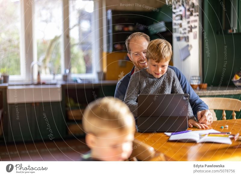 Vater benutzt Tablet zu Hause mit Kindern reales Leben echte Menschen Bonden Familie im Innenbereich qualitätsvolle Zeit Kindererziehung Genuss Tag Elternschaft