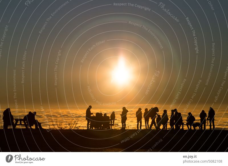 Menschen, die den Sonnenuntergang über den Wolken bestaunen Himmel Menschgruppe shilouette Wolkendecke Halo Lichtkreis Horizont mystisch außerirdisch
