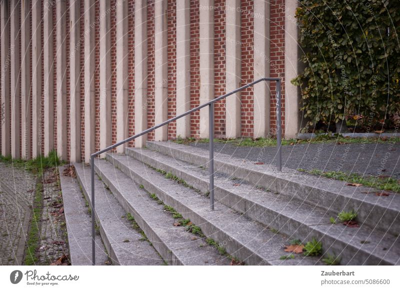 Treppenstufen und Geländer vor einer Ziegelwand mit vertikalen Streben aufwärts Wand elegant filigran Treppengeländer Architektur aufsteigen abwärts Perspektive