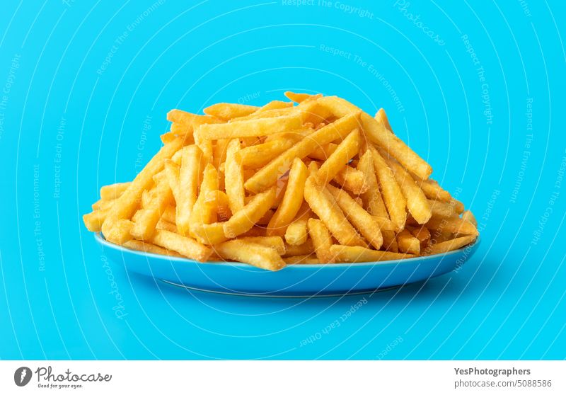Pommes frites auf einem Teller isoliert auf blauem Hintergrund Überfluss hell Kalorien Chip Nahaufnahme Farbe Konzept Textfreiraum Knusprig Küche ausschneiden