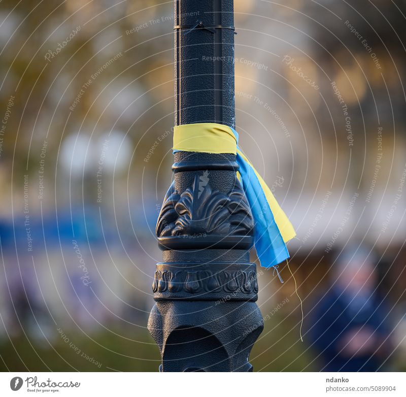 blaues und gelbes Seidenband, das auf ein Metallrohr gebunden ist. Symbol der ukrainischen Flagge, Kampf für die Unabhängigkeit Kherson Straße Gewebe Fahne