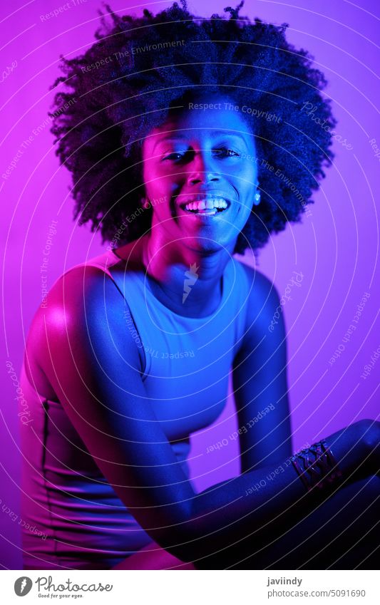 Fröhliches schwarzes Modell schaut in die Kamera Frau Stil neonfarbig leuchten Farbe Lächeln Glück hell Porträt jung Afroamerikaner ethnisch froh Individualität