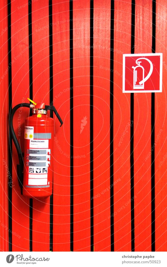 Roter Feuerlöscher an roter Wand Hörsaal Holz Zeichen Hinweisschild Warnschild bedrohlich Sicherheit Schutz gefährlich Häusliches Leben Brandschutz Paneele