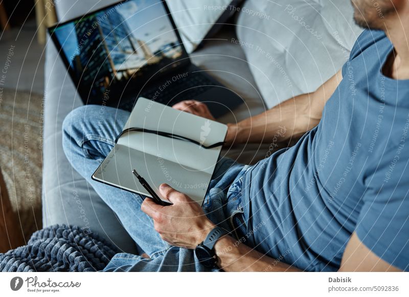 Mann sitzt auf Couch und benutzt Laptop Arbeit heimwärts abgelegen Arbeitsplatz Wohnzimmer Freiberufler Sitzen Komfort online Liege allein Business lernen