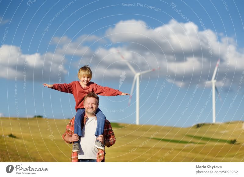 Öko-Aktivisten, Mann und Kind, vor dem Hintergrund von Kraftwerken zur Erzeugung erneuerbarer elektrischer Energie. Menschen und Windmühlen. Windturbinen zur Stromerzeugung. Grüne Energie