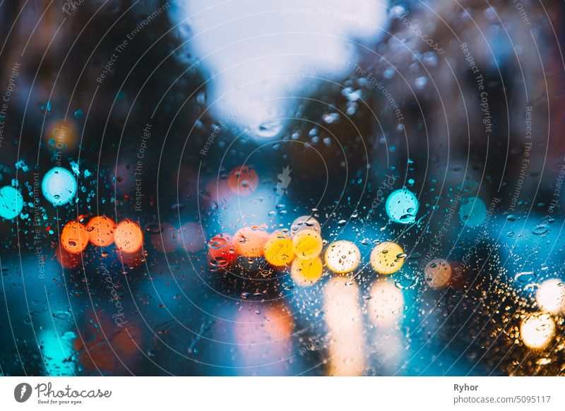 Rain Water Drops On Blue Glass Background In Night Or Evening Street Lights. Straße Bokeh Boke Lichter aus dem Fokus. Herbst Straße Abstrakte Kulisse lebhaft