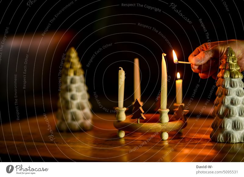Mann zündet Kerzen zum Advent an Weihnachten & Advent Adventskerzen Adventskranz anzünden adventszeit Streichholz entzünden Hand Kerzenschein festlich