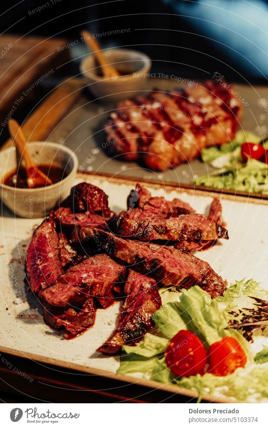 Rindfleisch in einem argentinischen Steakhaus Amerikaner aromatisch Hintergrund gebacken Barbecue gegrillt grillen Beefsteak schwarz Holzplatte Knochen