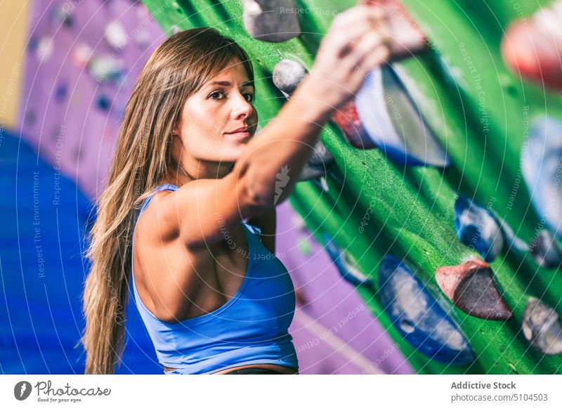 Sportlerin an der Kletterwand Aufstieg Wand Griff Fitnessstudio Training Bouldern stark Neigung anstrengen Frau packen hängen Aktivität extrem Herausforderung