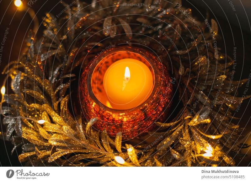 Golden glänzende festliche Kerze mit brennender Flamme als Heimdekoration. Weihnachtsferien Dekoration im Winter. Inneneinrichtung Details. Flach gelegt. Ansicht von oben.