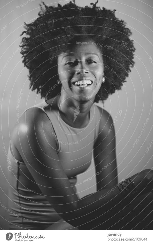 Schwarz-Weiß-Foto eines fröhlichen schwarzen Models, das in die Kamera schaut Frau Stil neonfarbig leuchten Lächeln Glück hell Porträt jung Afroamerikaner