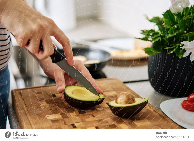 Frau schneidet Avocado auf einem Schneidebrett, um das Frühstück vorzubereiten organisch Lebensmittel Zuprosten Bestandteil Essen zubereiten Koch Küche