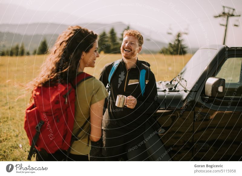 Lächelndes Paar bei der Vorbereitung eines Wanderabenteuers mit Rucksäcken in einem Geländewagen aktiv Aktivität Erwachsene Abenteuer Rucksack Backpacker