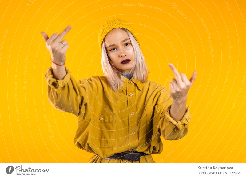Junge unhöfliche Frau auf gelbem Hintergrund zeigt Mittelfinger - Geste des Ficks. Finger gestikulieren Person jung Aggression zeigend Erwachsener Hand Zeichen